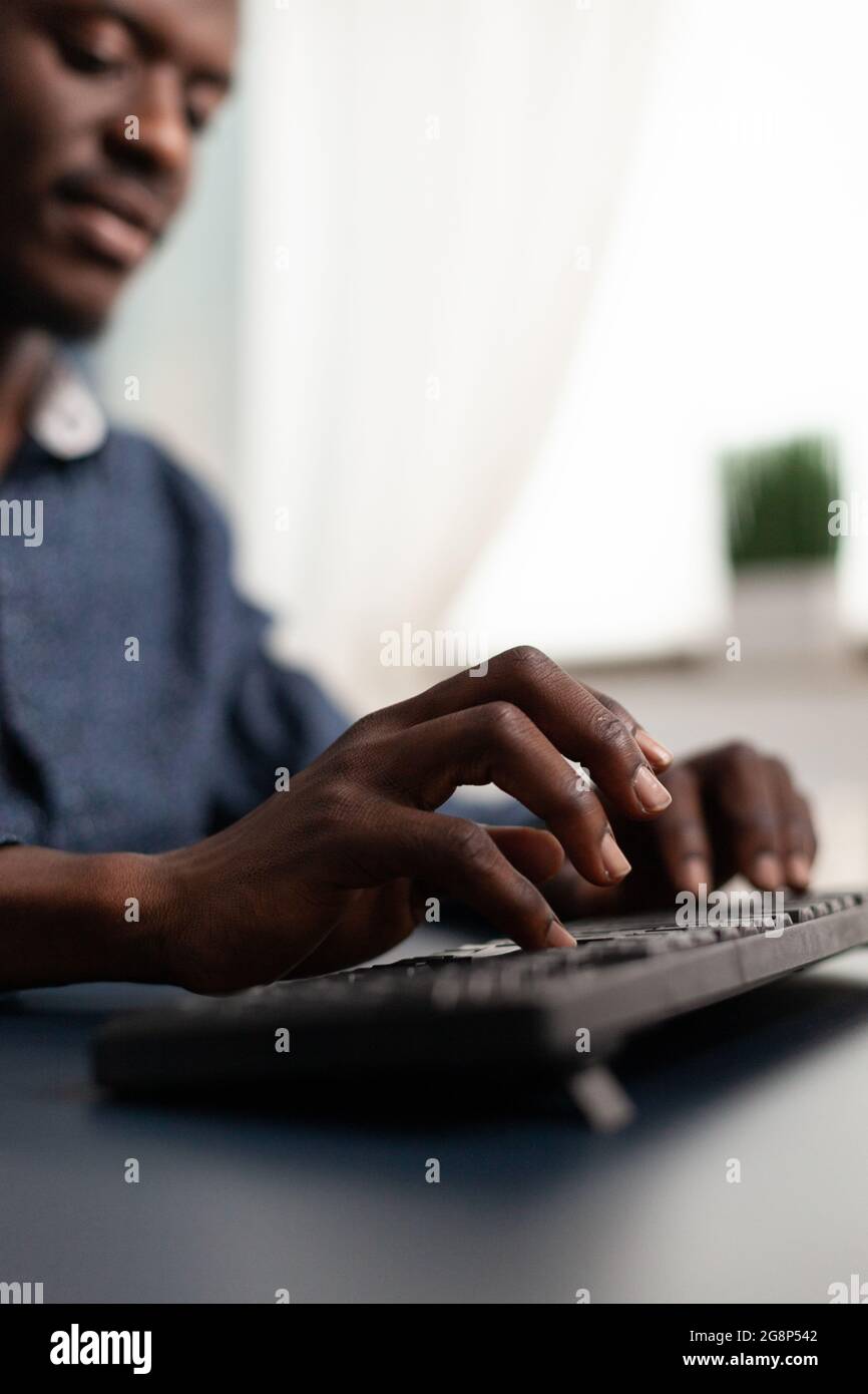 Personne afro-américaine noire dactylographiant sur le clavier de PC, travaillant à la maison. Utilisateur d'ordinateur à distance, homme d'affaires afro-américain faisant des tâches dans l'industrie du marketing et de la communication Banque D'Images