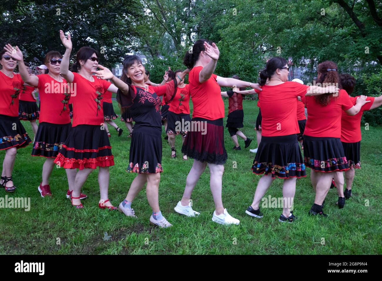 Un jour, ils se sont réunis pour des photos de groupe, une troupe asiatique américaine de femmes d'âge moyen dansant et faisant des gestes pour les caméras. À Queens, New York. Banque D'Images