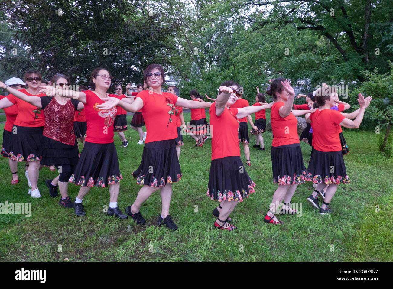 Un jour, ils se sont réunis pour des photos de groupe, une troupe asiatique américaine de femmes d'âge moyen dansant et faisant des gestes pour les caméras. À Queens, New York. Banque D'Images