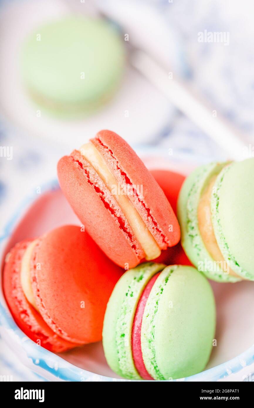 Thé aux papillons bleus et macarons ou macarons verts et orange Banque D'Images