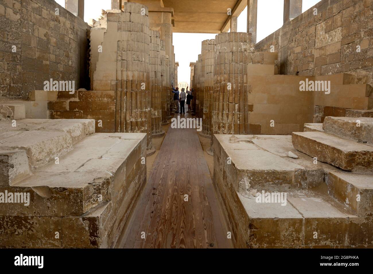 Les touristes admirent les colonnes sculptées en pierre de la salle Hypostyle à l'entrée de la pyramide Step (Pyramide de Djoser) à Saqqara, dans le nord de l'Égypte. Banque D'Images