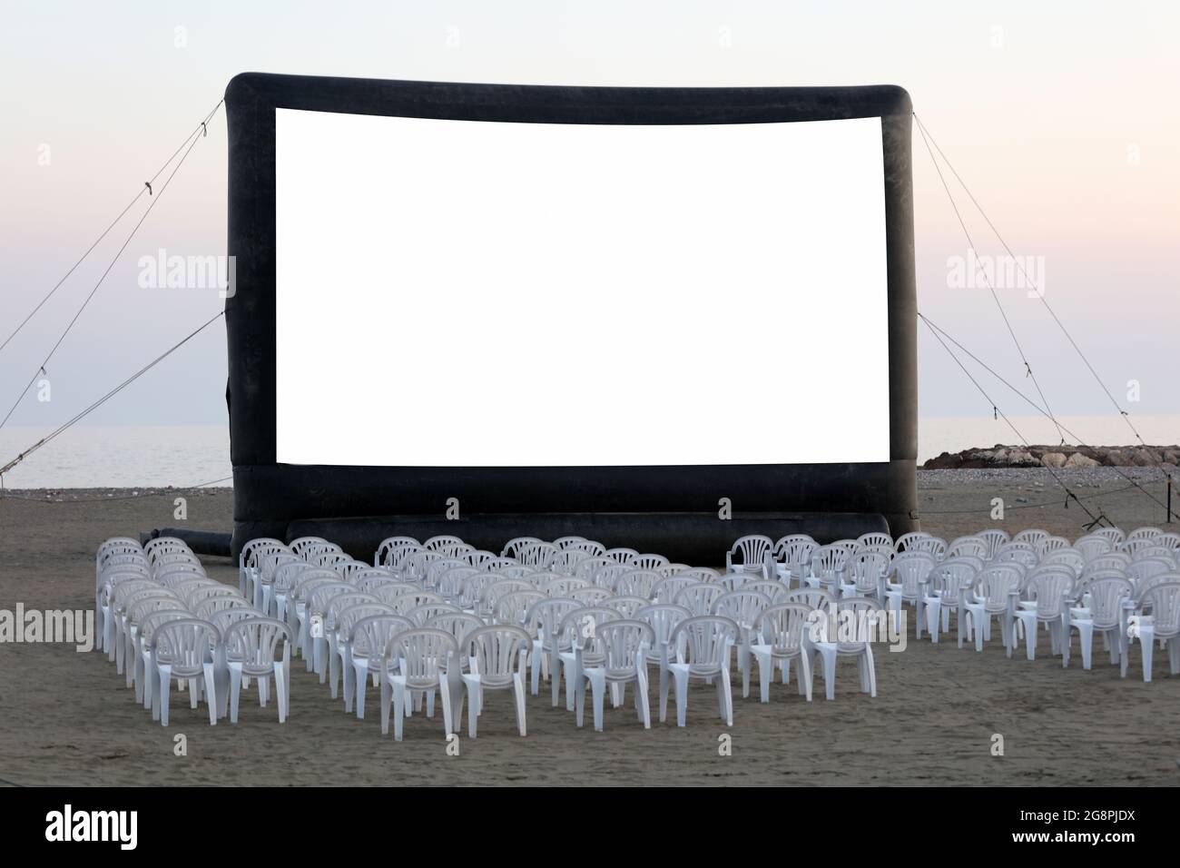 Un cinéma en plein air sur la plage au coucher du soleil. Avec des chaises,  personne Photo Stock - Alamy