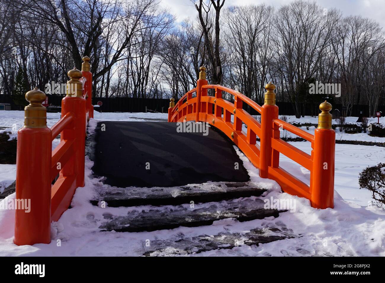 Pont rouge japonais avec neige dans l'étang pendant l'hiver à Noboribetsu Date JIdaimura Village historique, Hokkaido, Japon Banque D'Images