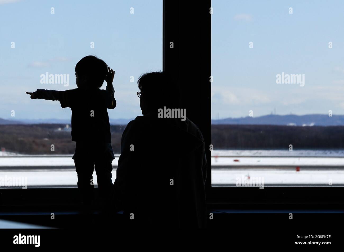 enfant et père regardant la fenêtre haute pendant la saison d'hiver Banque D'Images