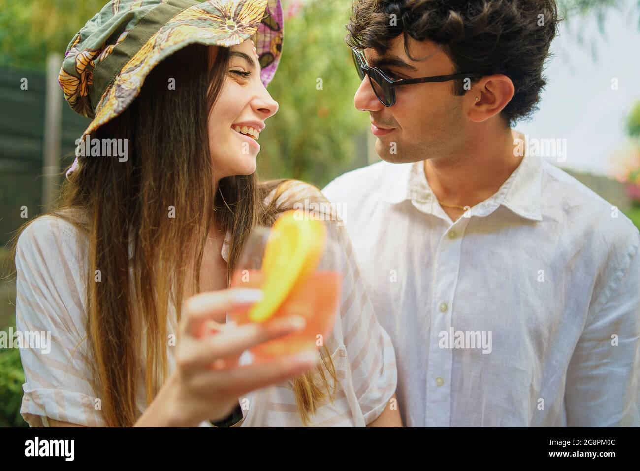 Un jeune couple adore boire du jus d'orange. Amour et de vacances concept. Banque D'Images