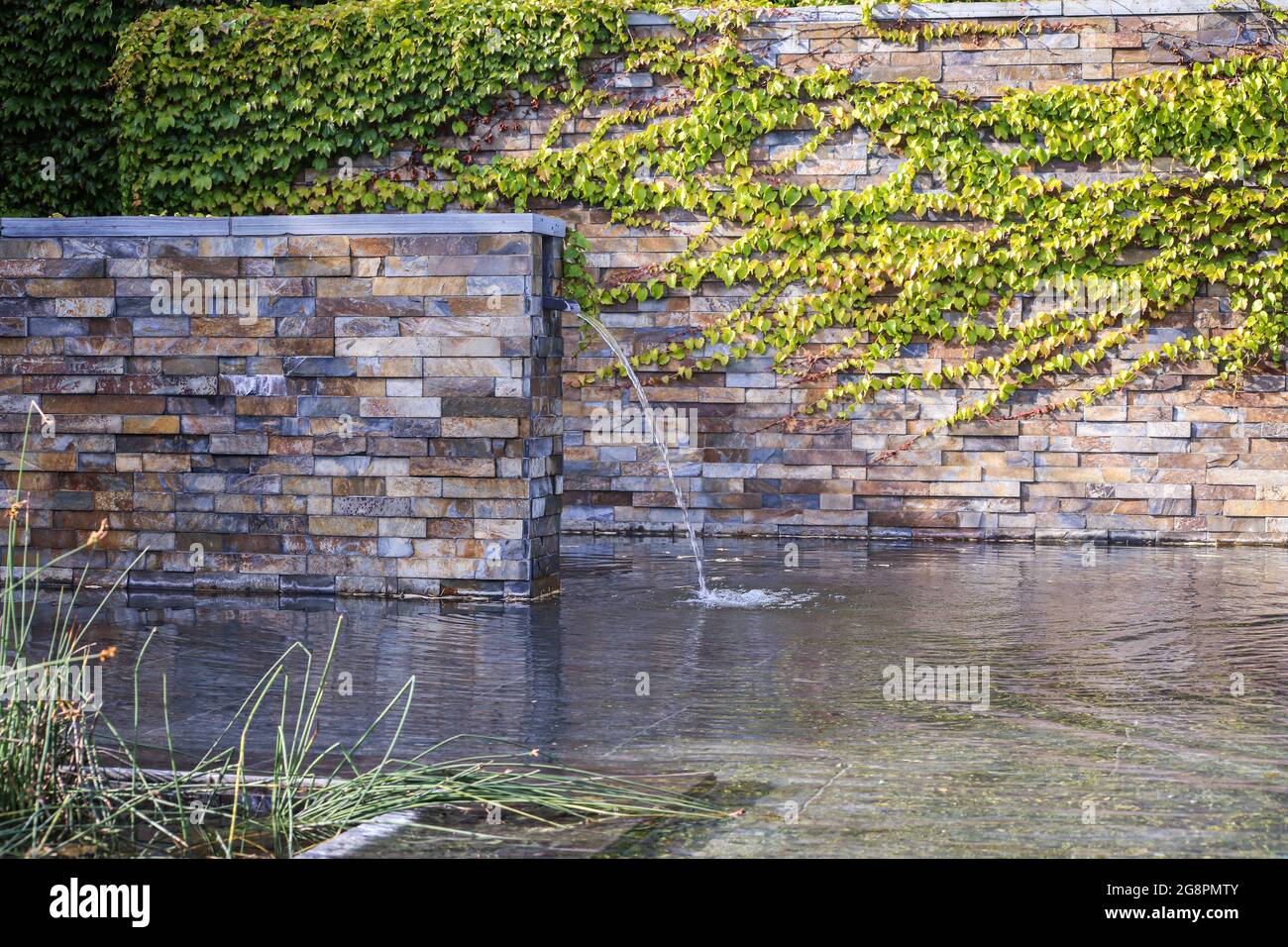 Une petite cascade décorative dans le jardin. Aménagement paysager Banque D'Images