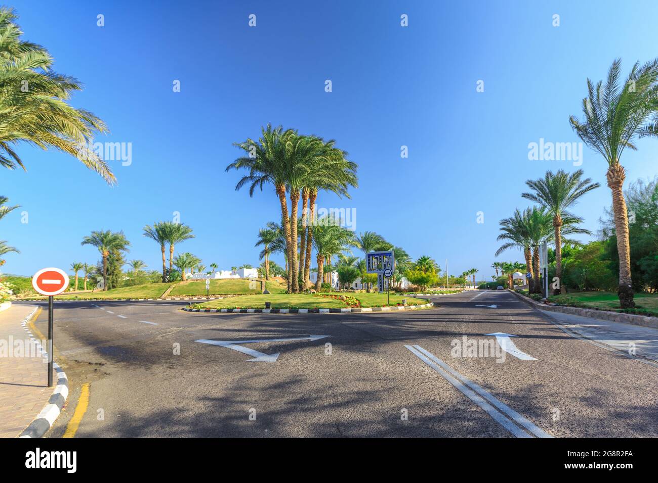 La vue sur la route et les palmiers près des bâtiments du territoire des hôtels en Egypte Banque D'Images