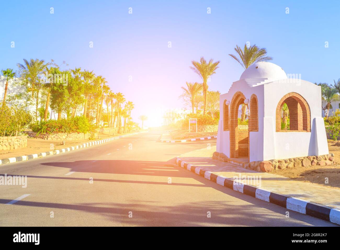 La vue sur la route et les palmiers près des bâtiments du territoire des hôtels en Egypte Banque D'Images