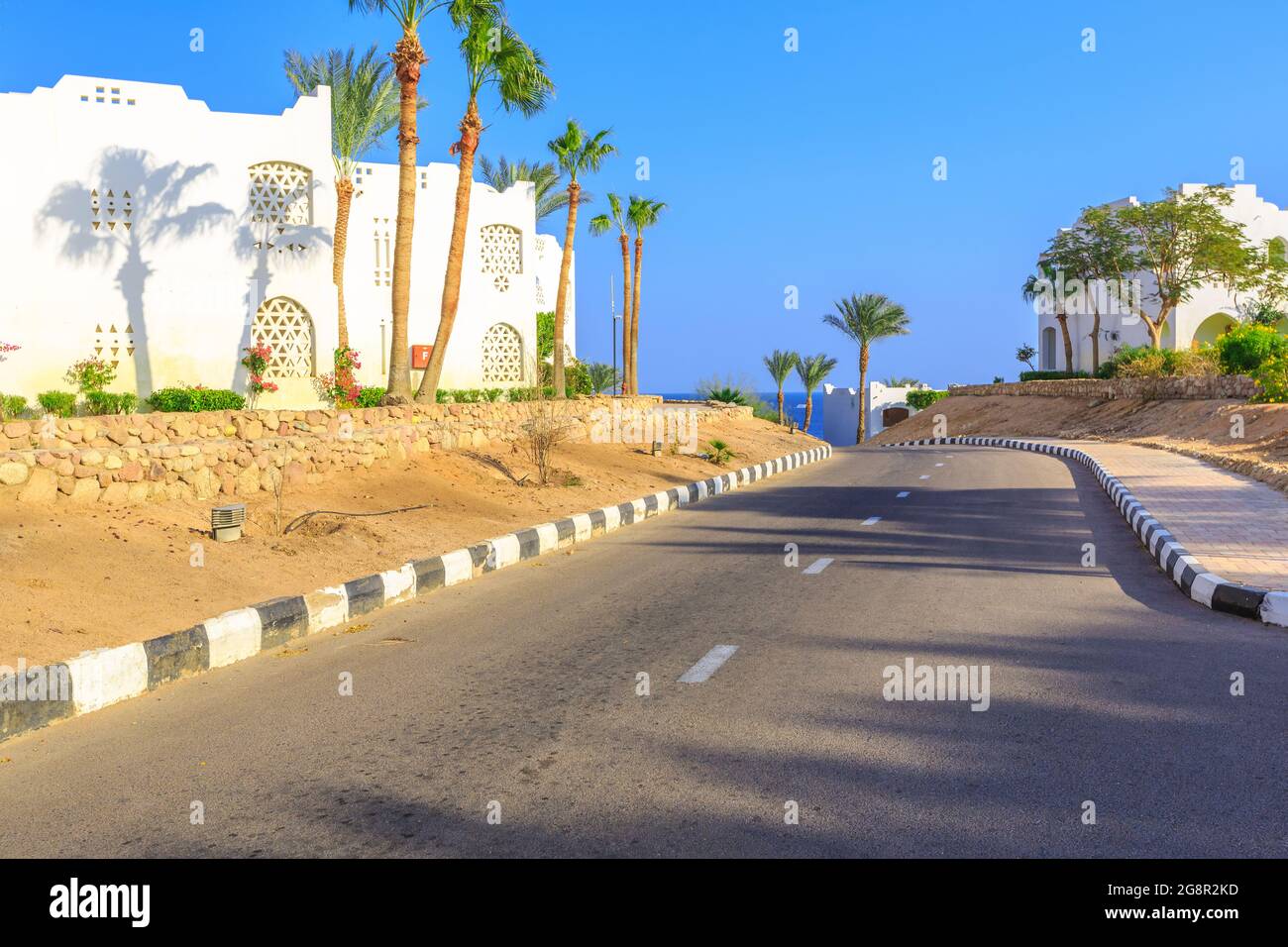 La vue sur la route et les palmiers près des bâtiments du territoire des hôtels en Egypte Banque D'Images
