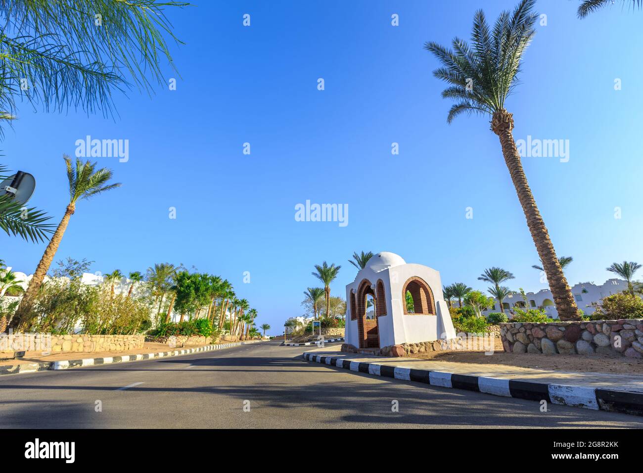 La vue sur la route et les palmiers près des bâtiments du territoire des hôtels en Egypte Banque D'Images