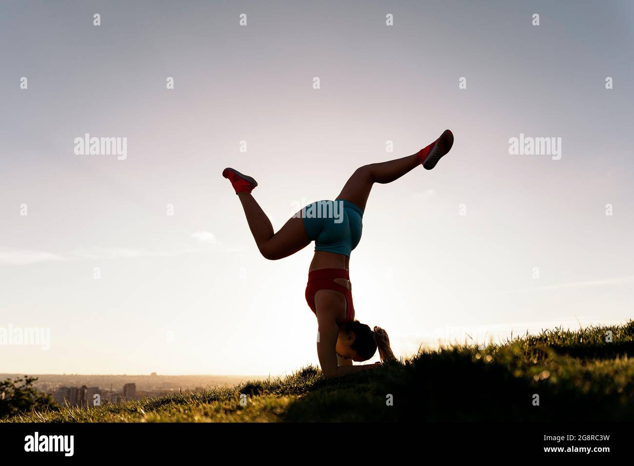 Femme non reconnue portant des vêtements de sport faisant de la pose de yoga et de l'entraînement dans le parc. Elle est forte et flexible. Banque D'Images