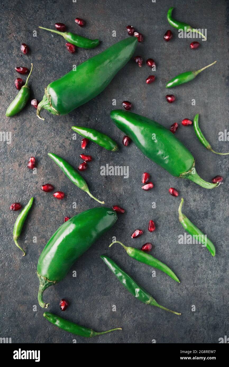 Pépins de jalapeno verts et graines de grenade sur fond noir Banque D'Images