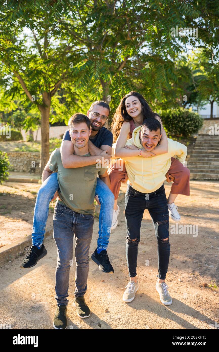 Groupe d'amis du Caucase s'amusant dans le parc. Ils sont heureux et rient. Ils portent des vêtements colorés. Par temps ensoleillé. Ils sont au-dessus de Banque D'Images