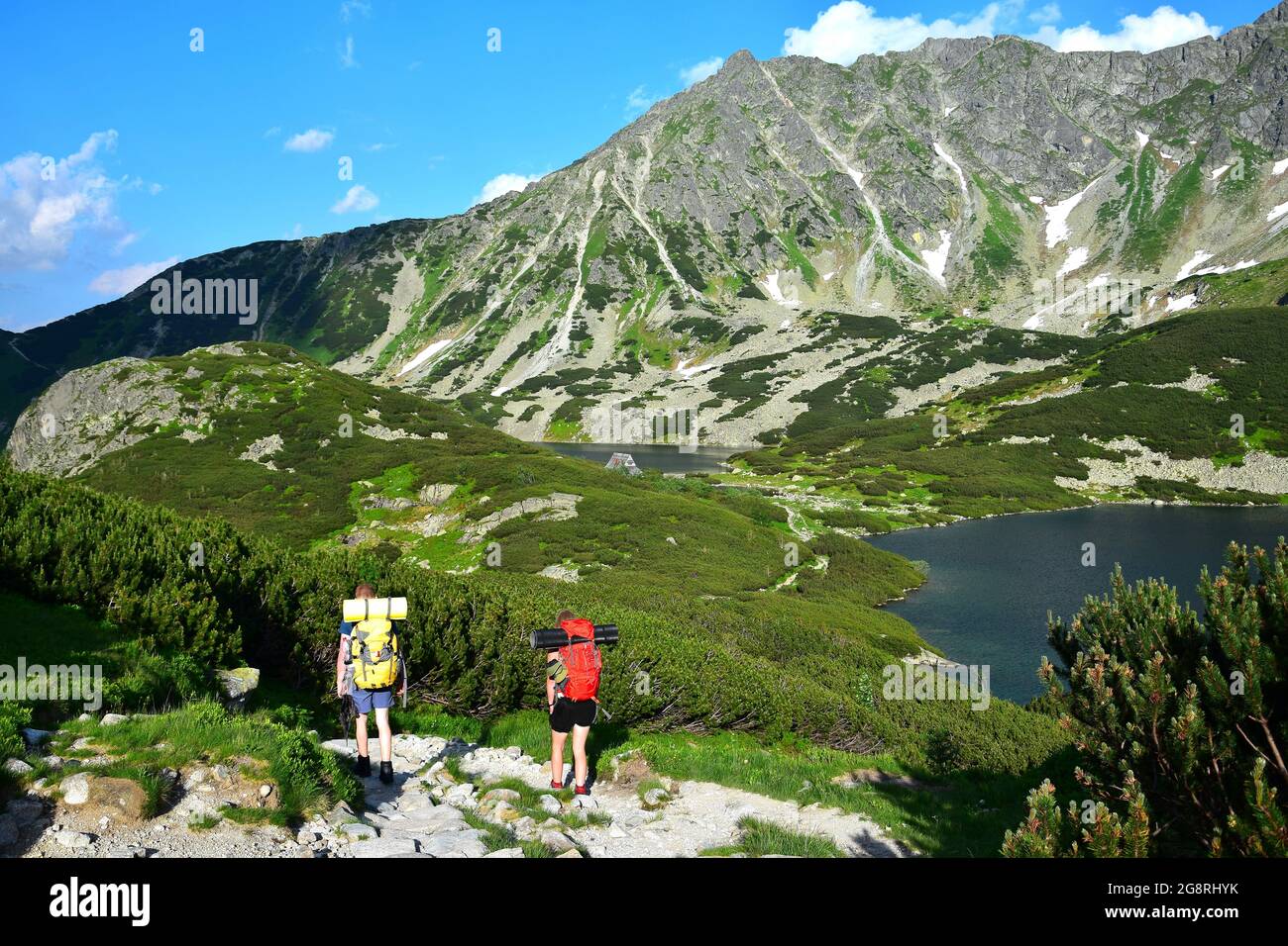 Deux randonneurs sur un sentier le long du magnifique lac Wielki Staw dans les Hautes Tatras, Pologne. Lac Przedni Staw en arrière-plan. Banque D'Images