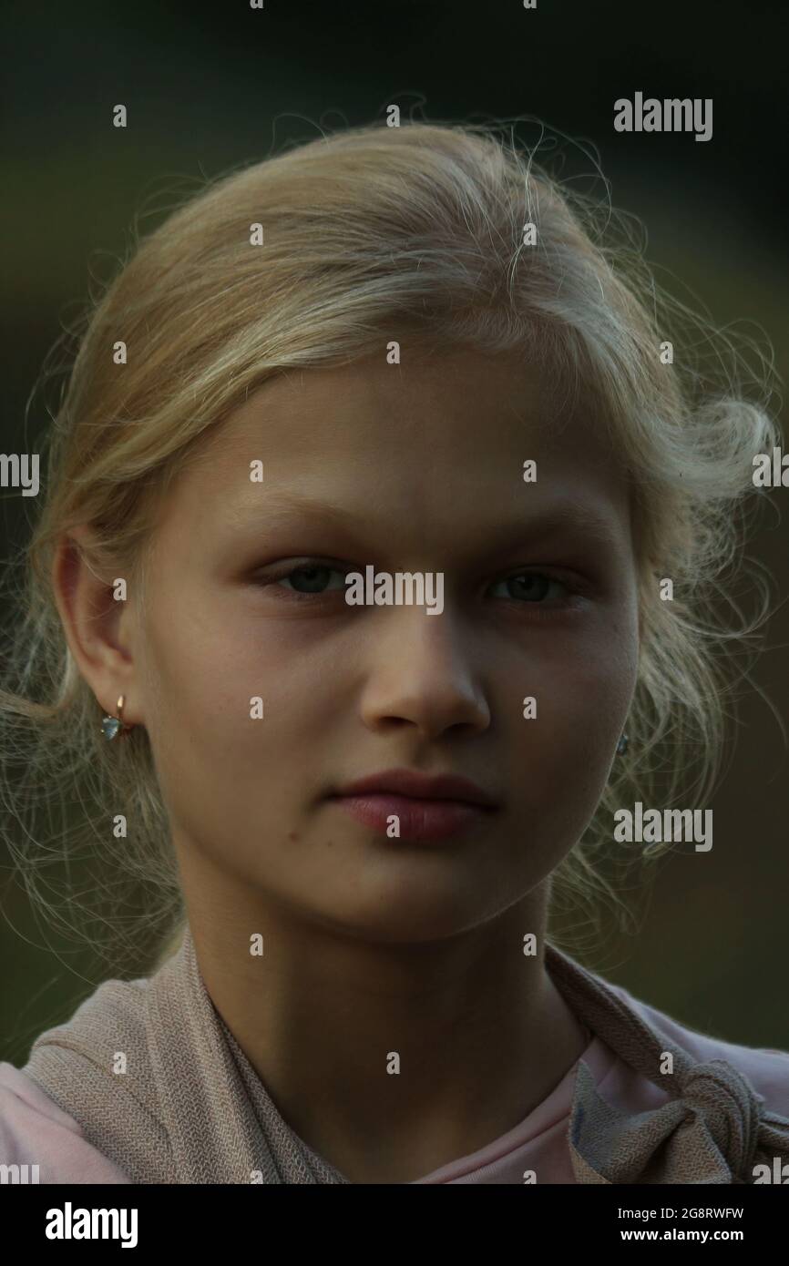 Portrait d'une fille blonde dans la lumière du soir à l'extérieur. Banque D'Images Portrait d'une fille blonde dans la lumière du soir à l'extérieur. Banque D'Images