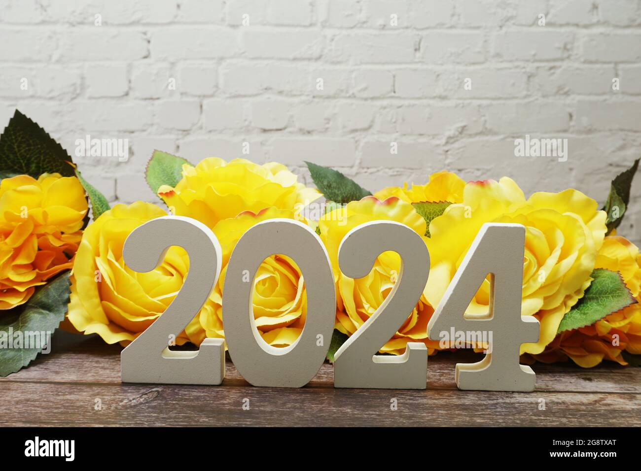 2024 bonne année avec Roses Flower Décoration avec copie de l'espace sur le mur de briques blanches Banque D'Images