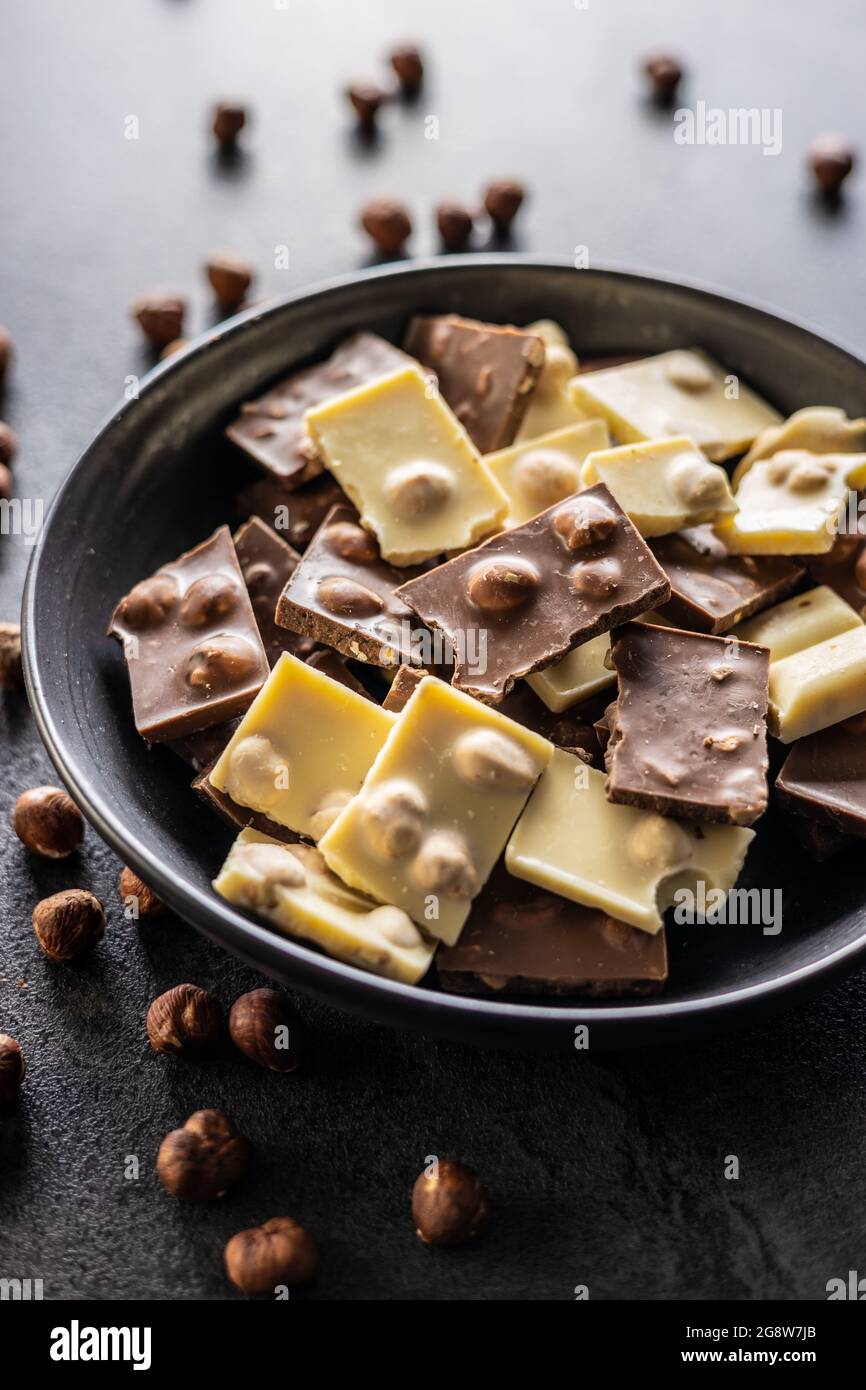 Chocolat noir et blanc noisette avec noisettes sur l'assiette. Banque D'Images