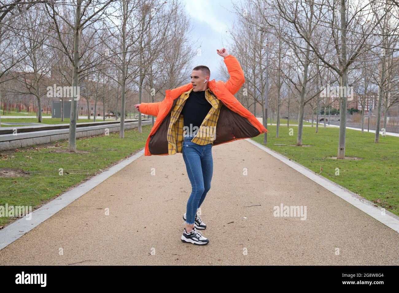 Un jeune homme qui porte du maquillage danse dans un parc. Rotation. Banque D'Images