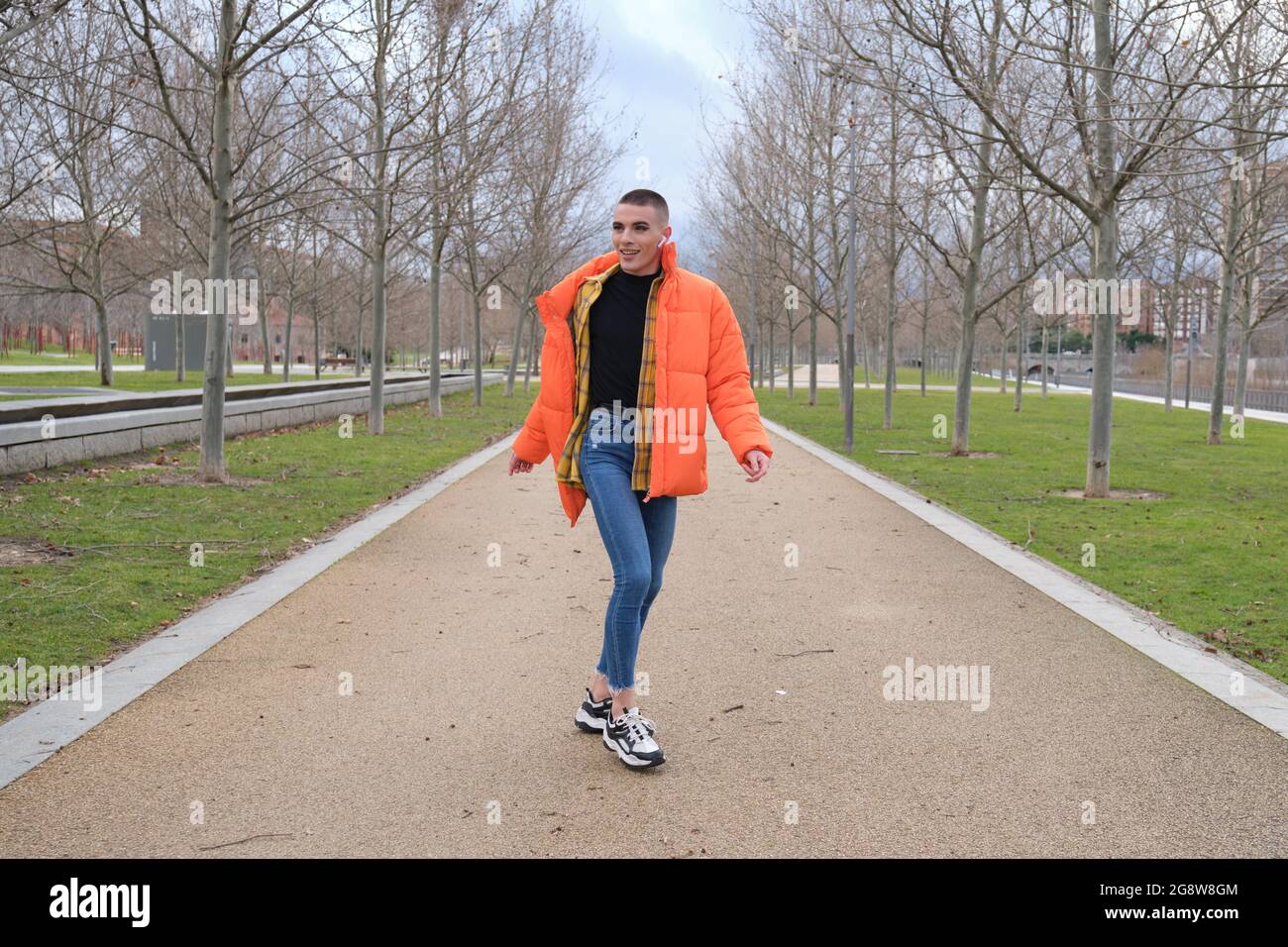 Un jeune homme qui porte du maquillage danse dans un parc. Rotation. Banque D'Images
