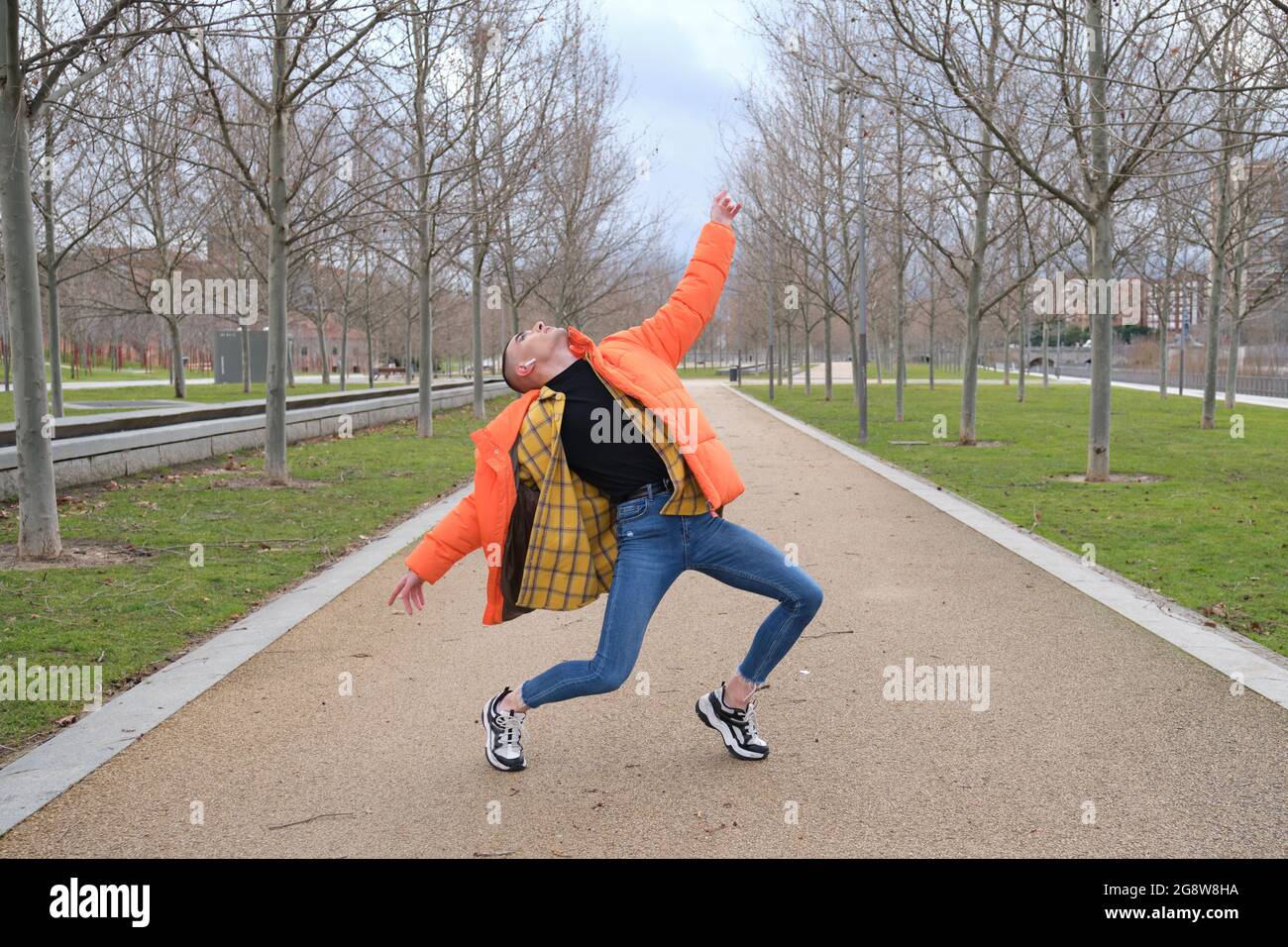 Un jeune homme qui porte du maquillage danse dans un parc. Danse dramatique à l'extérieur. Banque D'Images