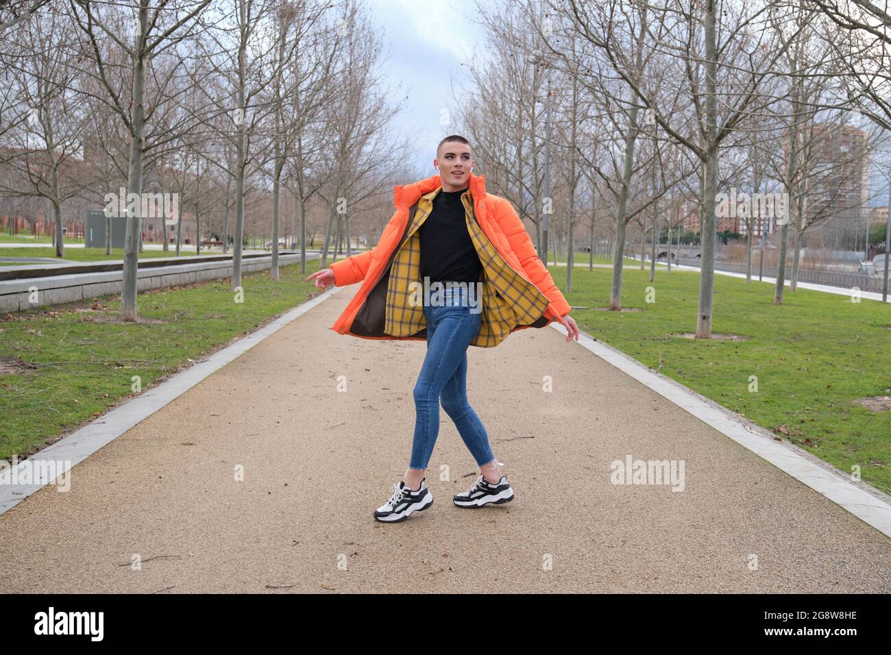 Un jeune homme qui porte du maquillage danse dans un parc. Rotation. Banque D'Images