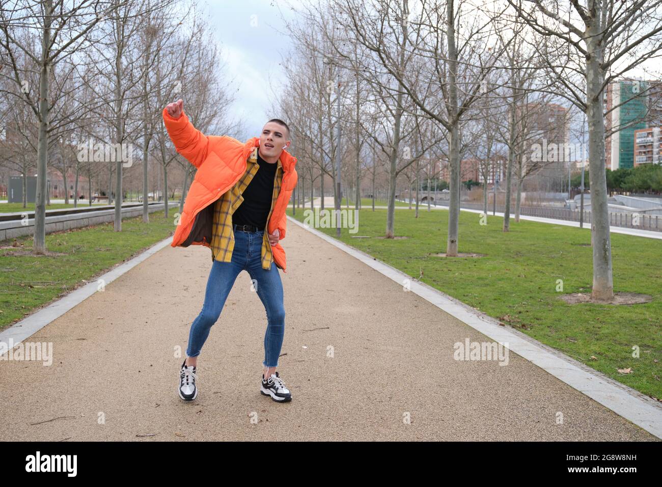 Un jeune homme qui porte du maquillage danse dans un parc. Danse fraîche. Banque D'Images
