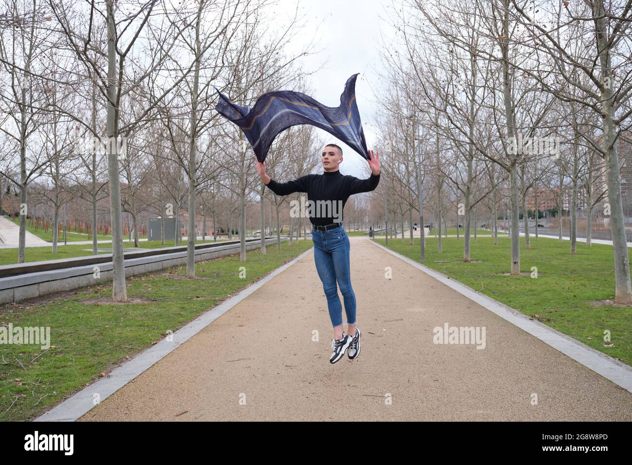 Un jeune homme qui porte du maquillage danse dans un parc. Saut en ballet. Banque D'Images