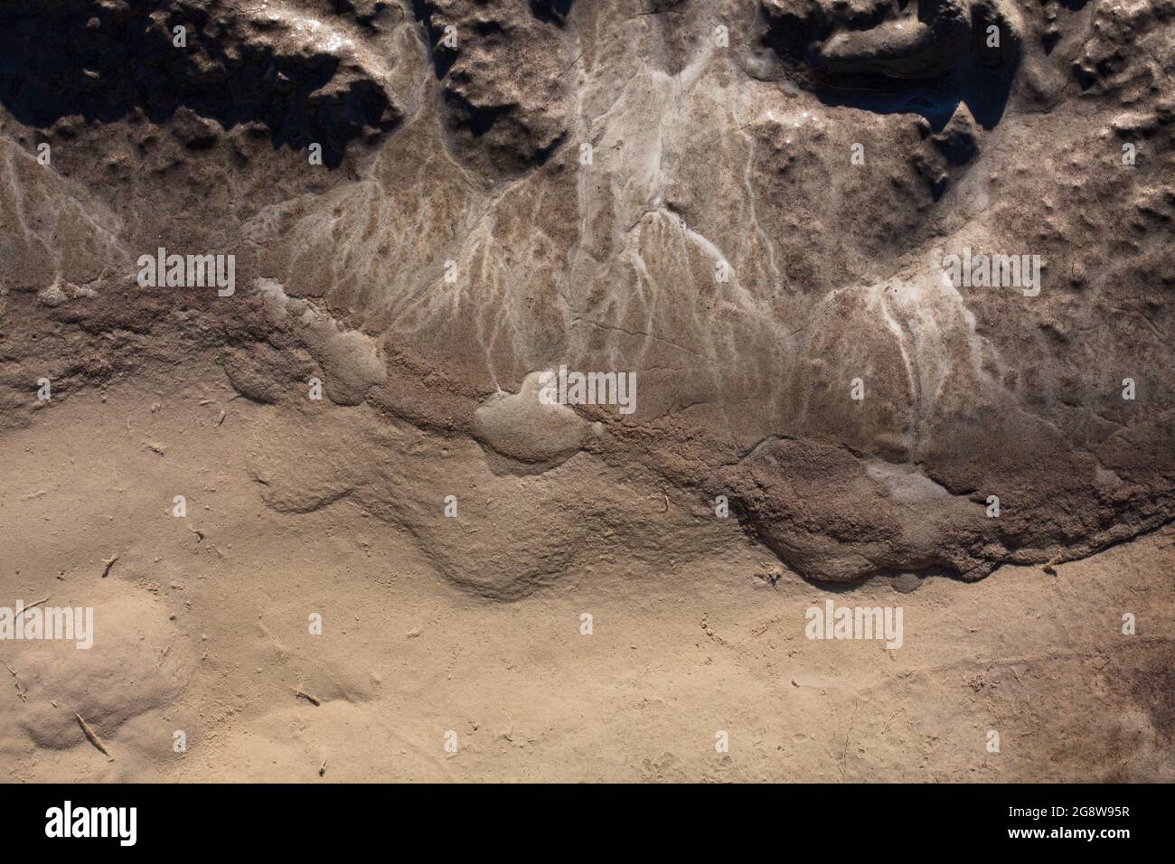 Caractéristiques géographiques à micro-échelle dans le limon après une inondation de rivière. Le paysage ressemble à des images satellites, avec des canyons, des vallées fluviales et des deltas. Banque D'Images