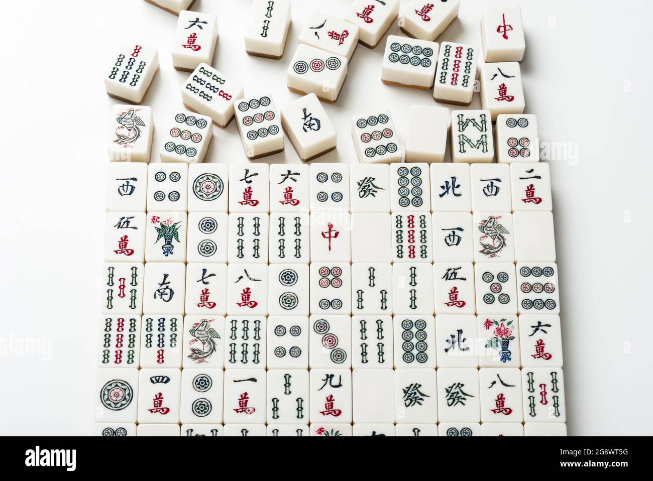 De nombreuses anciennes tuiles de mahjong sur fond blanc. Mahjong est l'ancien jeu de société asiatique. Banque D'Images