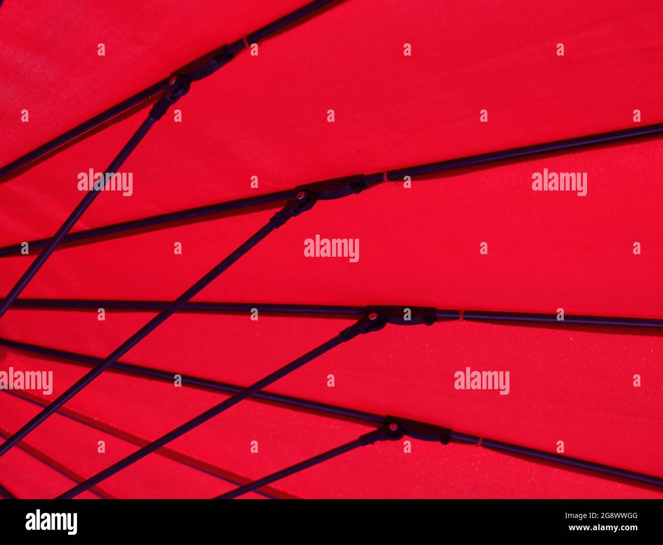 Image géométrique du dessous d'un parasol en tissu rouge Banque D'Images