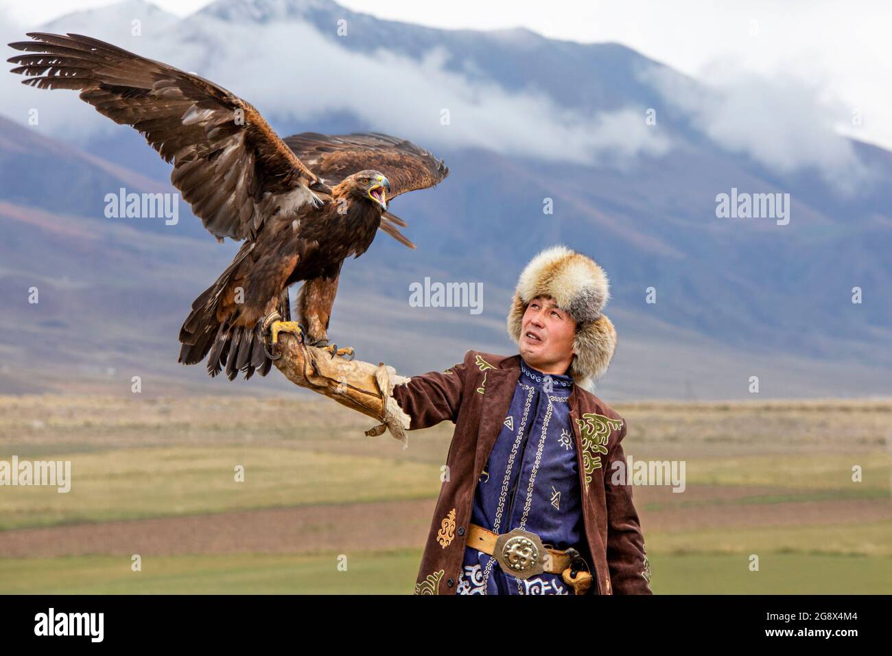 Chasseur d'aigle et son aigle d'or à Issyk Kul, Kirghizistan Banque D'Images