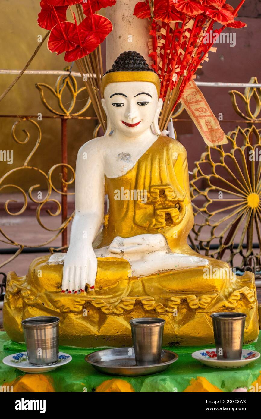 Bonne chance en versant de l'eau sur la tête de la statue de Bouddha, Myanmar Banque D'Images
