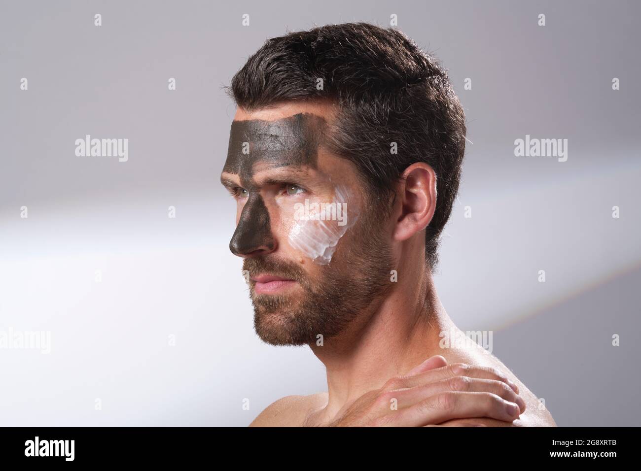 Homme utilisant des produits du visage sur sa peau. Masques pour le visage. Masques rajeunissants et hydratant. Banque D'Images