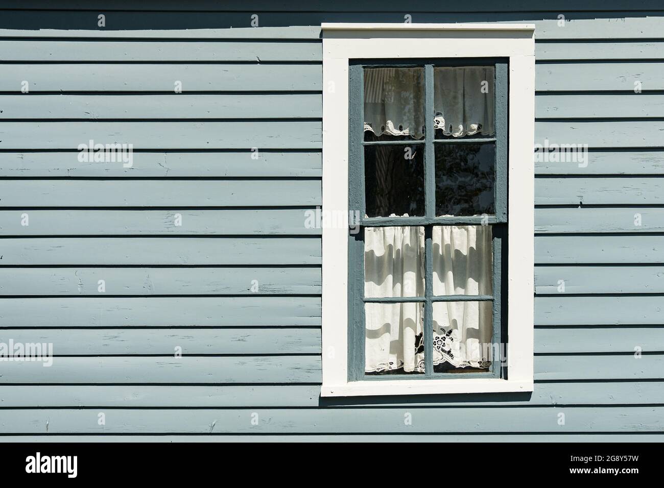 Fenêtre grise et blanche peinte à l'ancienne avec panneaux de rideau horizontaux Banque D'Images