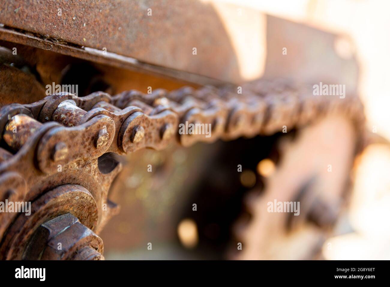 Détails rouillés des vieilles voitures abandonnées. Les pignons, les chaînes et les poulies rouillent dans l'ouverture. Pièces métalliques recouvertes de mousse de machines agricoles. Banque D'Images