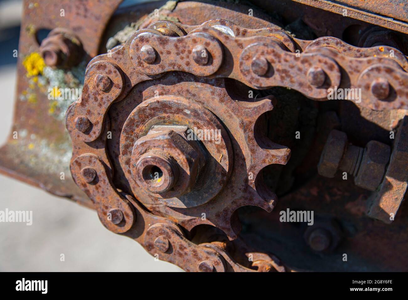 Détails rouillés des vieilles voitures abandonnées. Les pignons, les chaînes et les poulies rouillent dans l'ouverture. Pièces métalliques recouvertes de mousse de machines agricoles. Banque D'Images