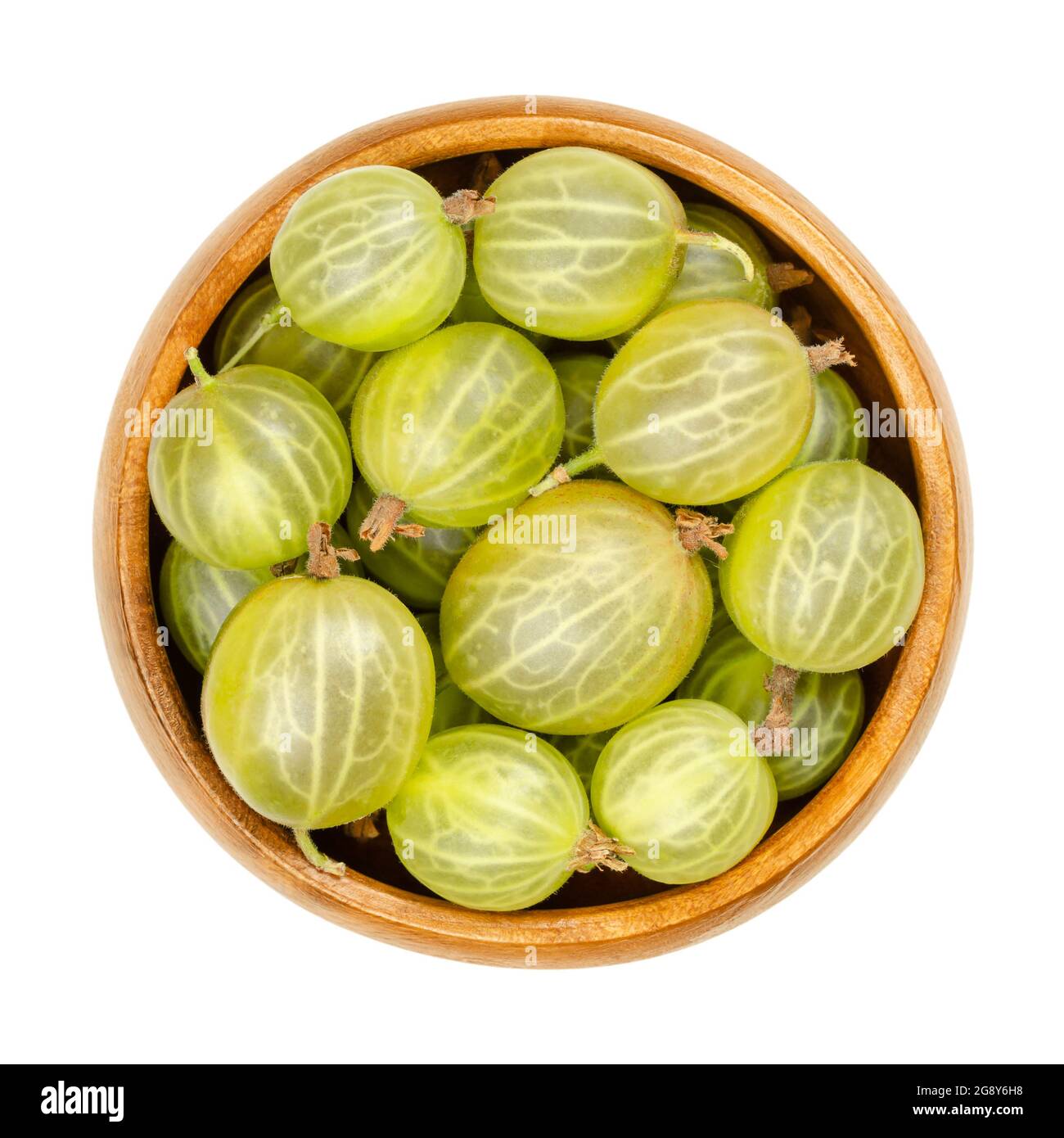 Groseilles à maquereau vertes dans un bol en bois. Baies fraîches et mûres, fruits de Ribes, également connus sous le nom de groseille d'Europe, au goût doux et sourish. Banque D'Images