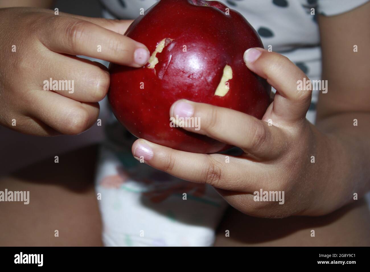 Apple dans les mains d'un enfant de 3 ans. Banque D'Images