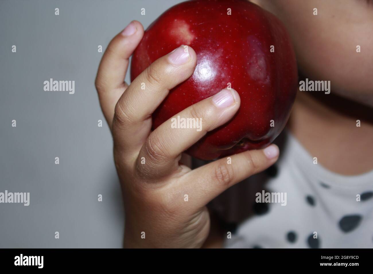 Apple dans les mains d'un enfant de 3 ans. Banque D'Images