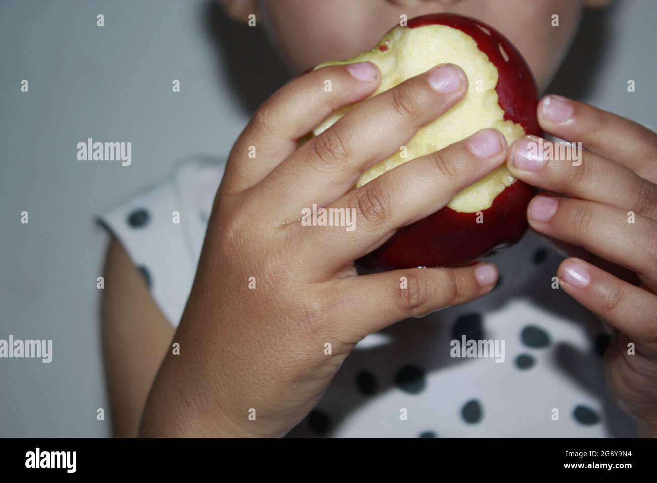 Apple dans les mains d'un enfant de 3 ans. Banque D'Images