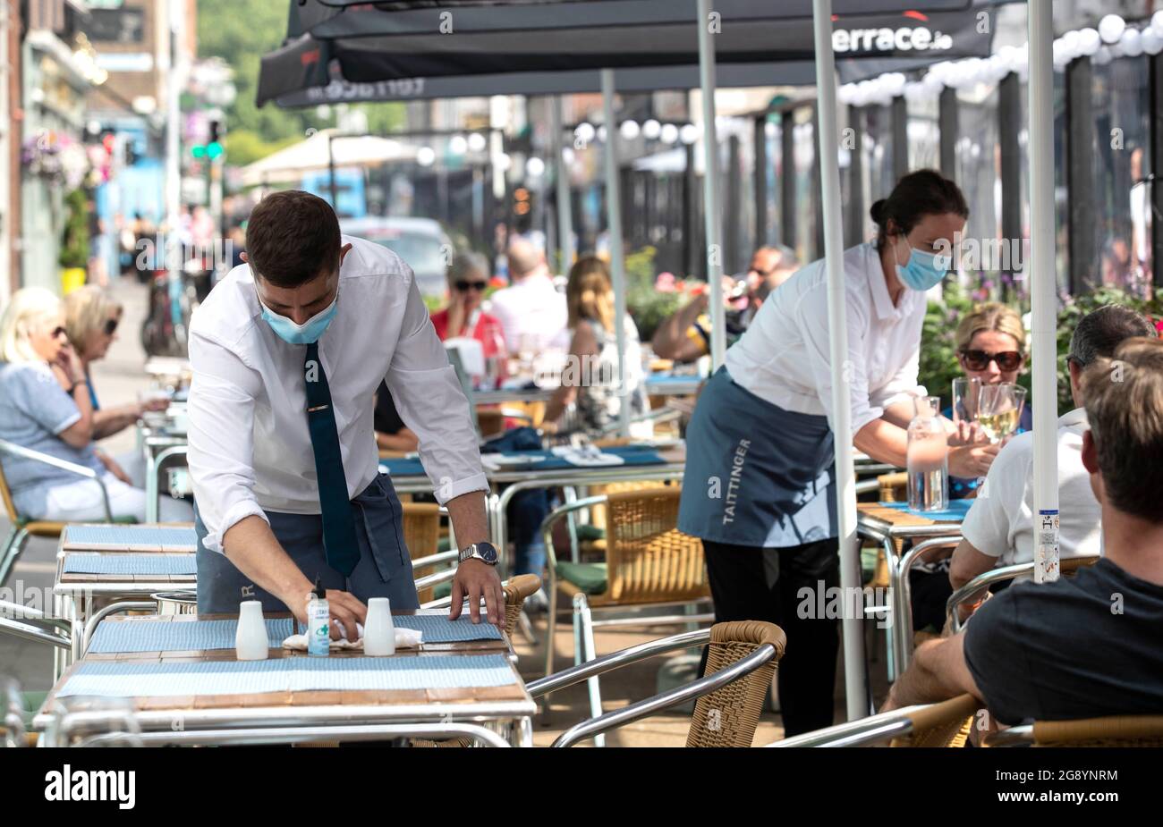 Un serveur fixe une table devant le restaurant Hugo sur Merrion Row à Dublin, où il rouvrira ses portes pour dîner à l'intérieur le jeudi 29 juillet. Date de la photo : vendredi 23 juillet 2021. Banque D'Images