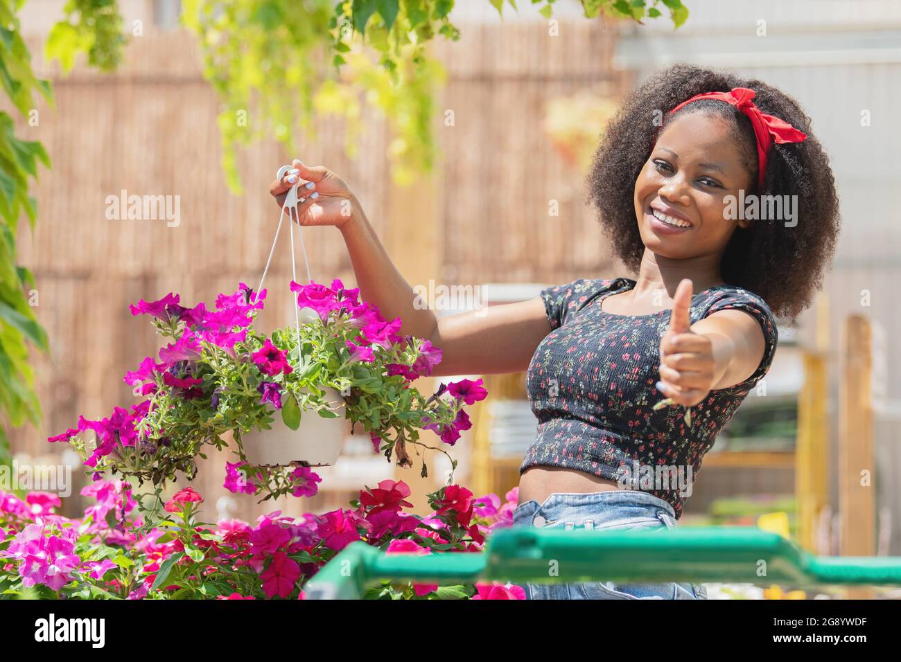 Femme gestante pour être bien tout en tenant des fleurs dans un magasin Banque D'Images