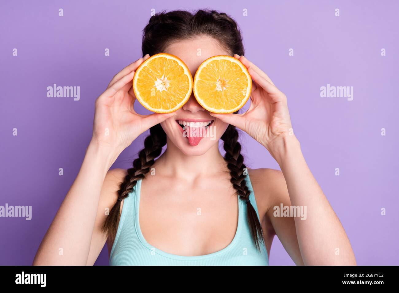 Photo de funky drôle jeune femme couverture yeux tranche orange bâton hors  langue isolée sur fond violet de couleur Photo Stock - Alamy
