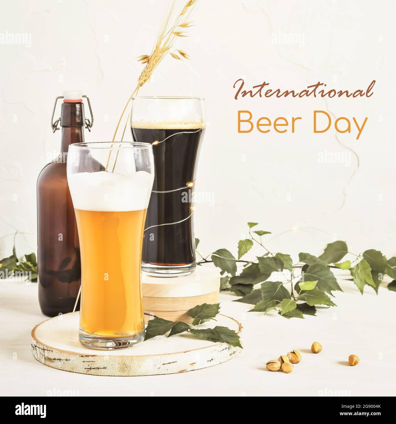 La Journée internationale de la bière est une célébration le premier vendredi de chaque mois d'août. Des verres de bière froide et foncée, des pistaches et des feuilles sur un bac blanc Banque D'Images