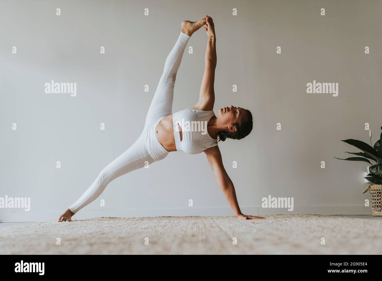 Instructeur de yoga féminin flexible avec des jambes à part s'entraîner au club de santé Banque D'Images