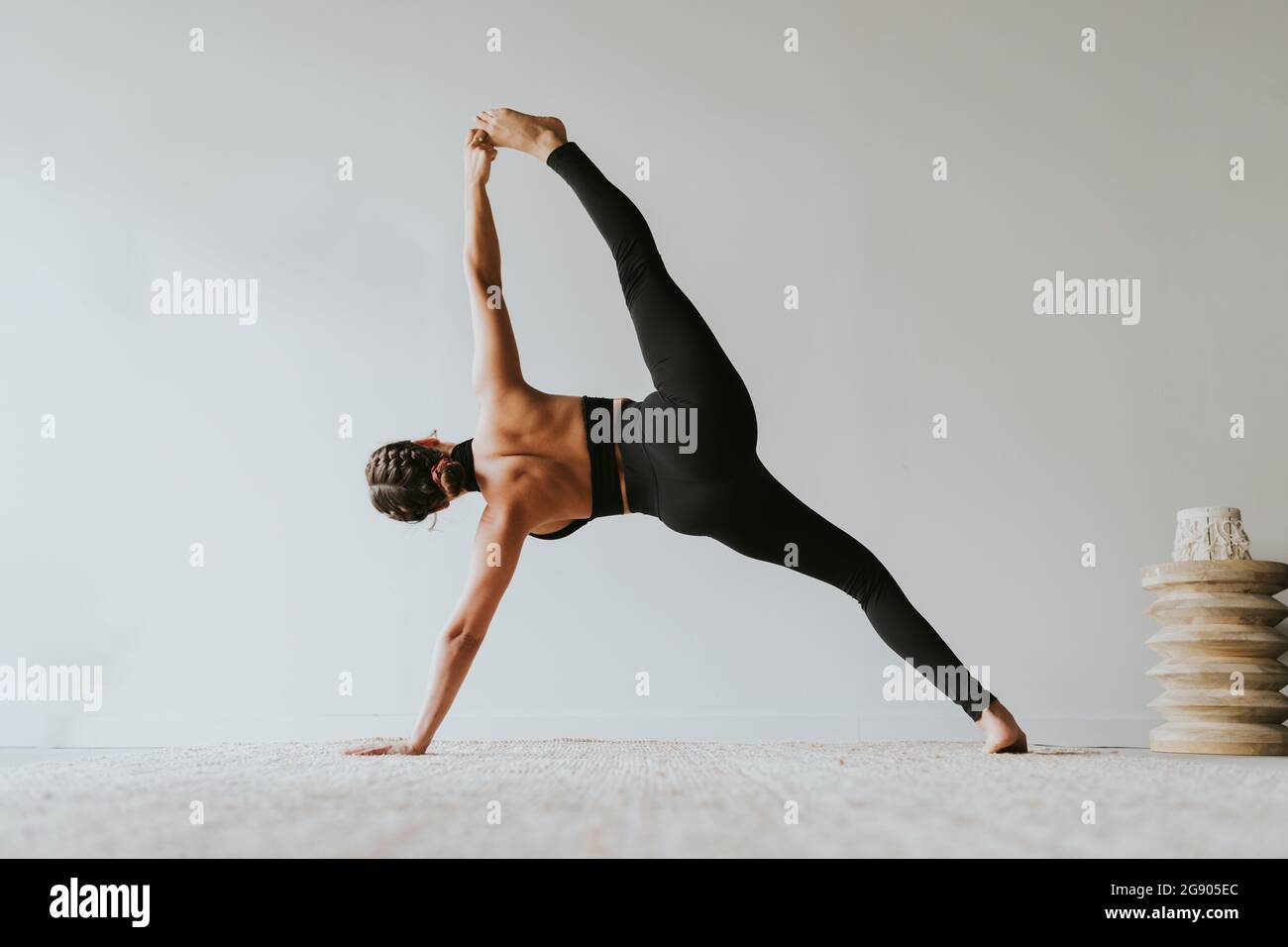 Enseignante de fitness avec des jambes à part pratiquer le yoga au club de santé Banque D'Images