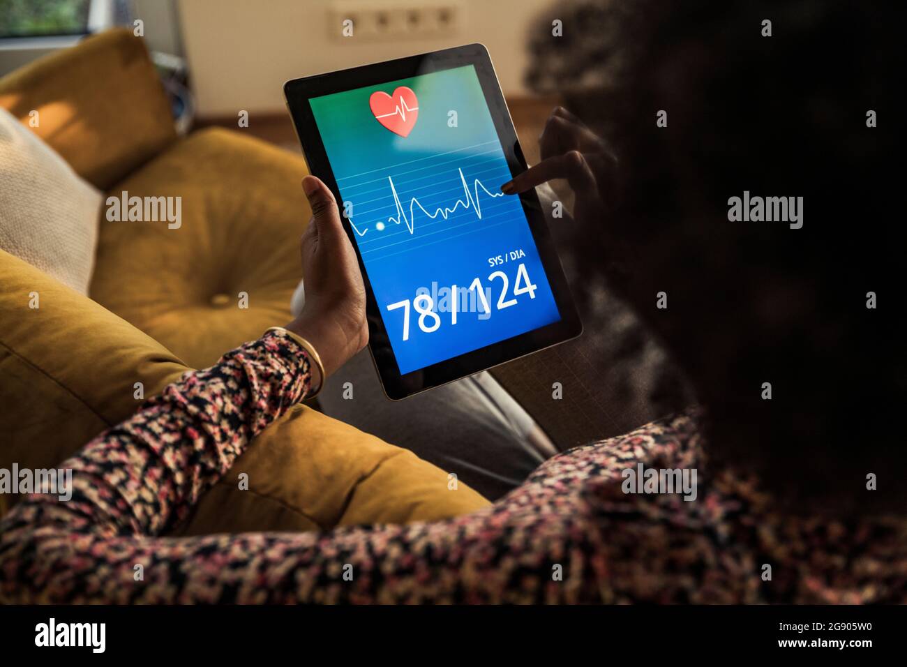 Femme vérifiant le rapport de santé sur une tablette numérique à la maison Banque D'Images