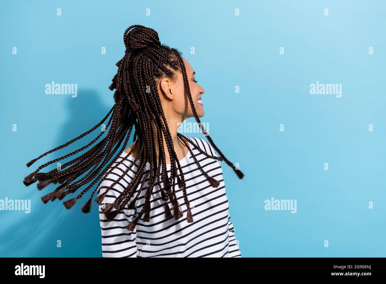 Profil latéral photo portrait de fille avec dreadlocks gai sourire jet de cheveux isolé pastel bleu couleur fond Banque D'Images