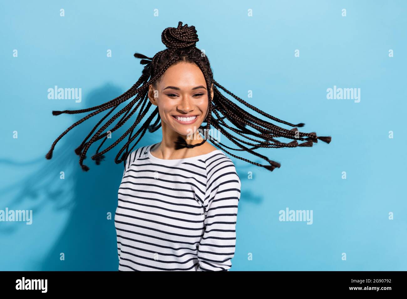 Photo portrait d'une fille avec des dreadlocks joyeux rire heureux overjoyed jet cheveux isolé couleur bleu pastel arrière-plan Banque D'Images