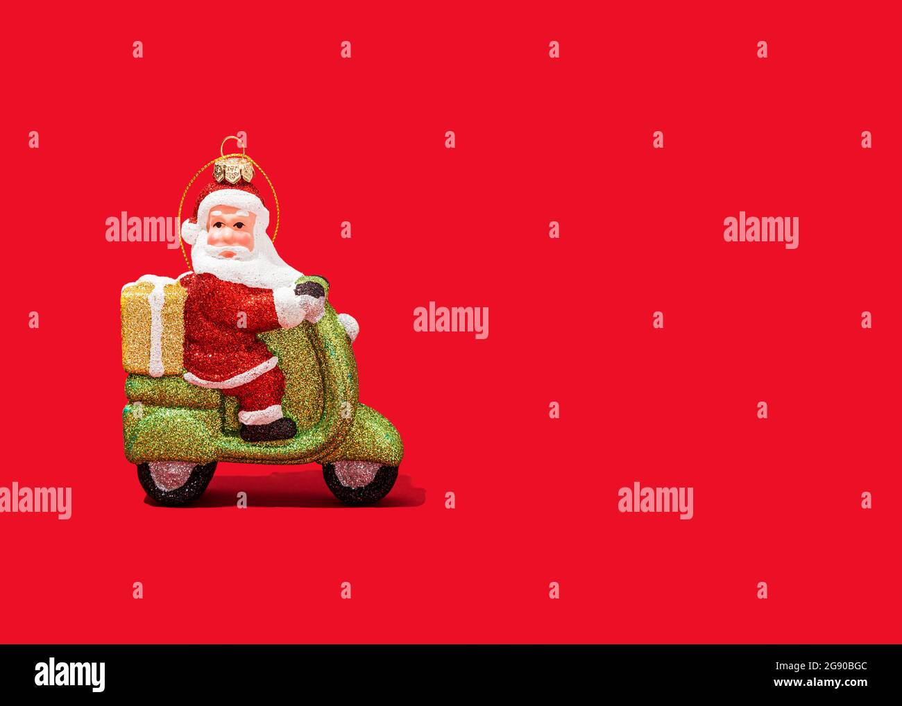Décoration de Noël du scooter des roues du Père Noël sur fond rouge vif Banque D'Images